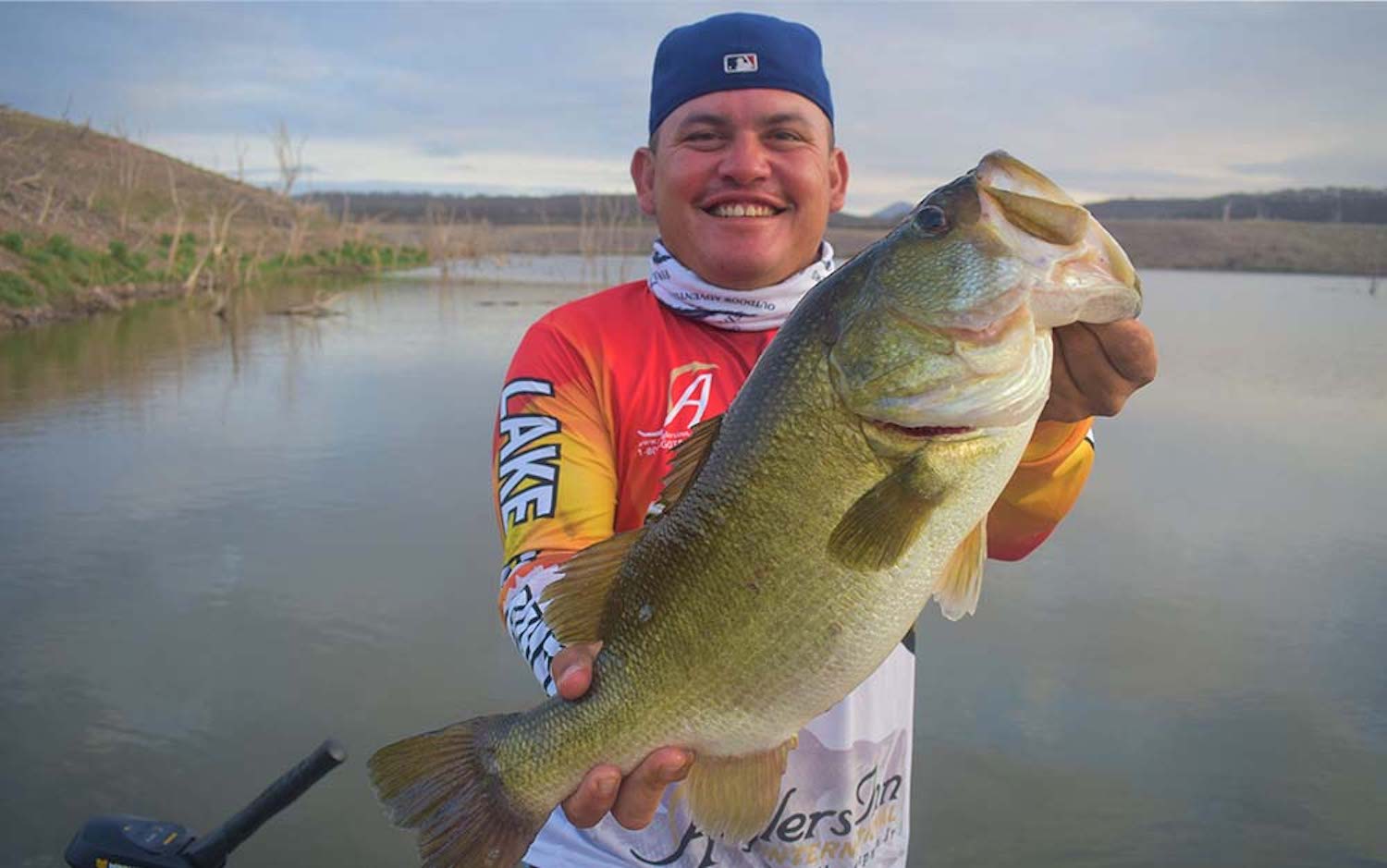 A man holding a large green spring bass