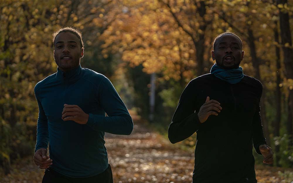 Two men running wearing Ibex merino woolies tech
