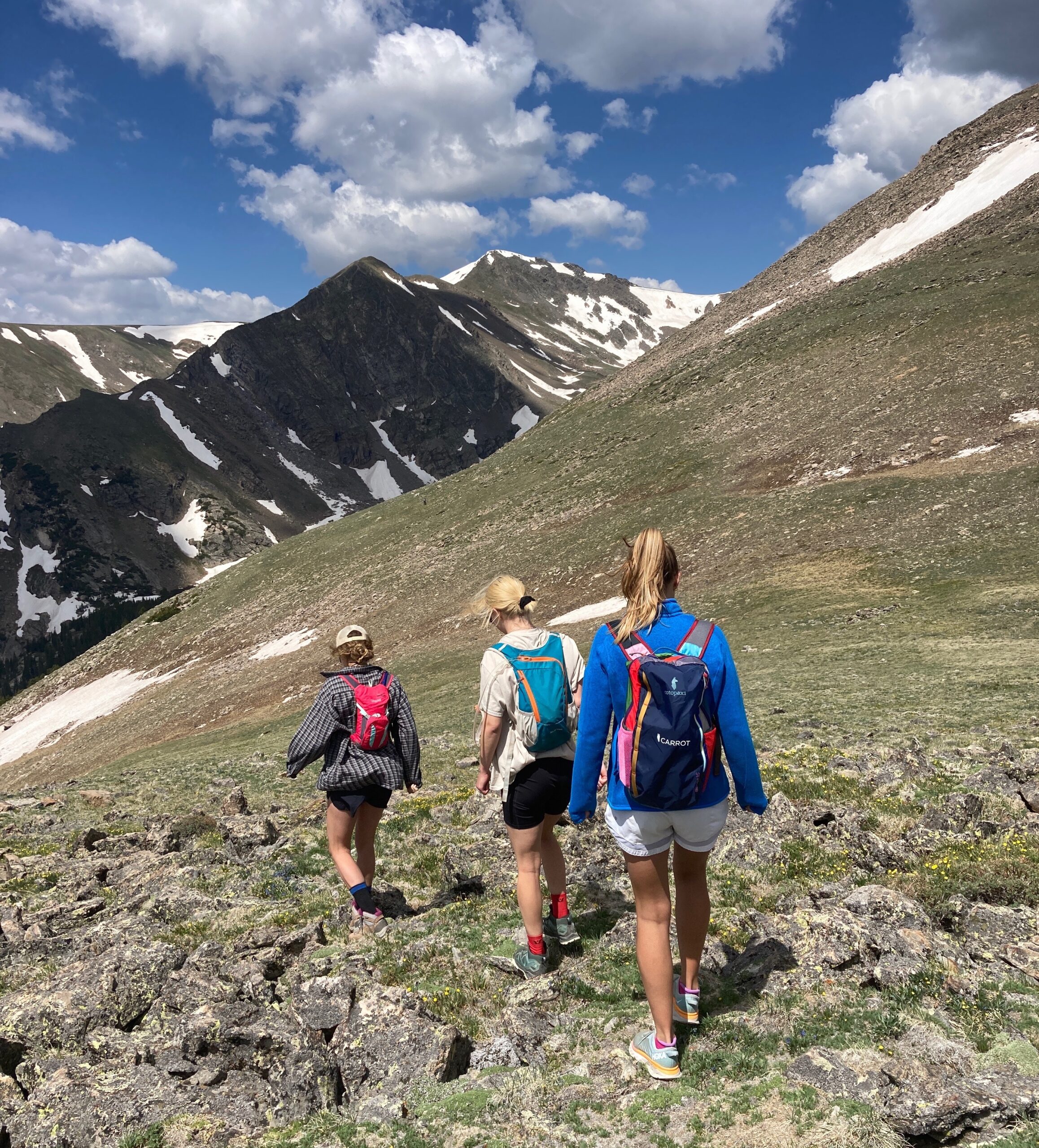 Three women hiking in the mountains wearing the best hiking backpacks