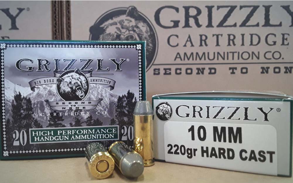 Two boxes of best 10mm ammo behind three gold bullets