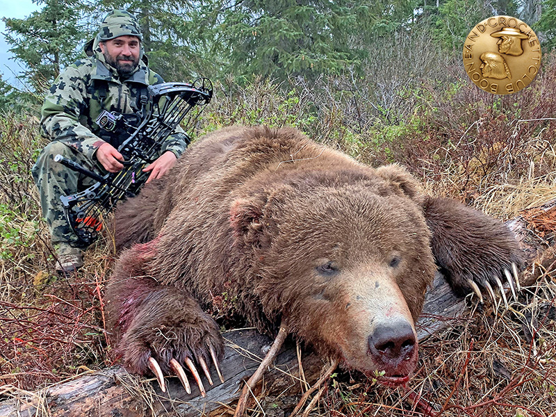 Jared Bradshaw with a bow-shot brown bear. 