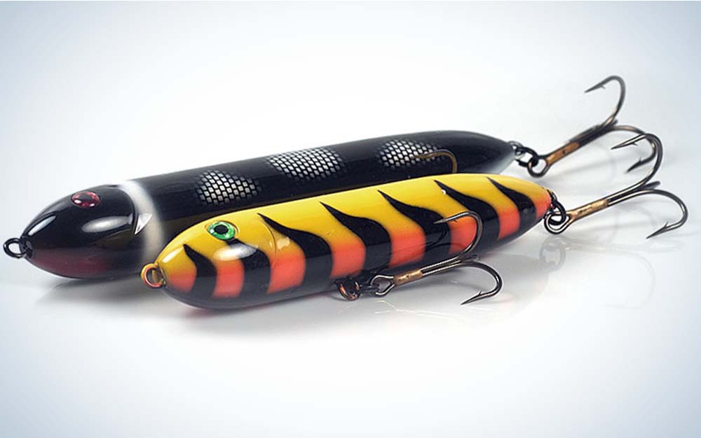 One black striped bass lure and one yellow and orange striped bass lure with black stripes