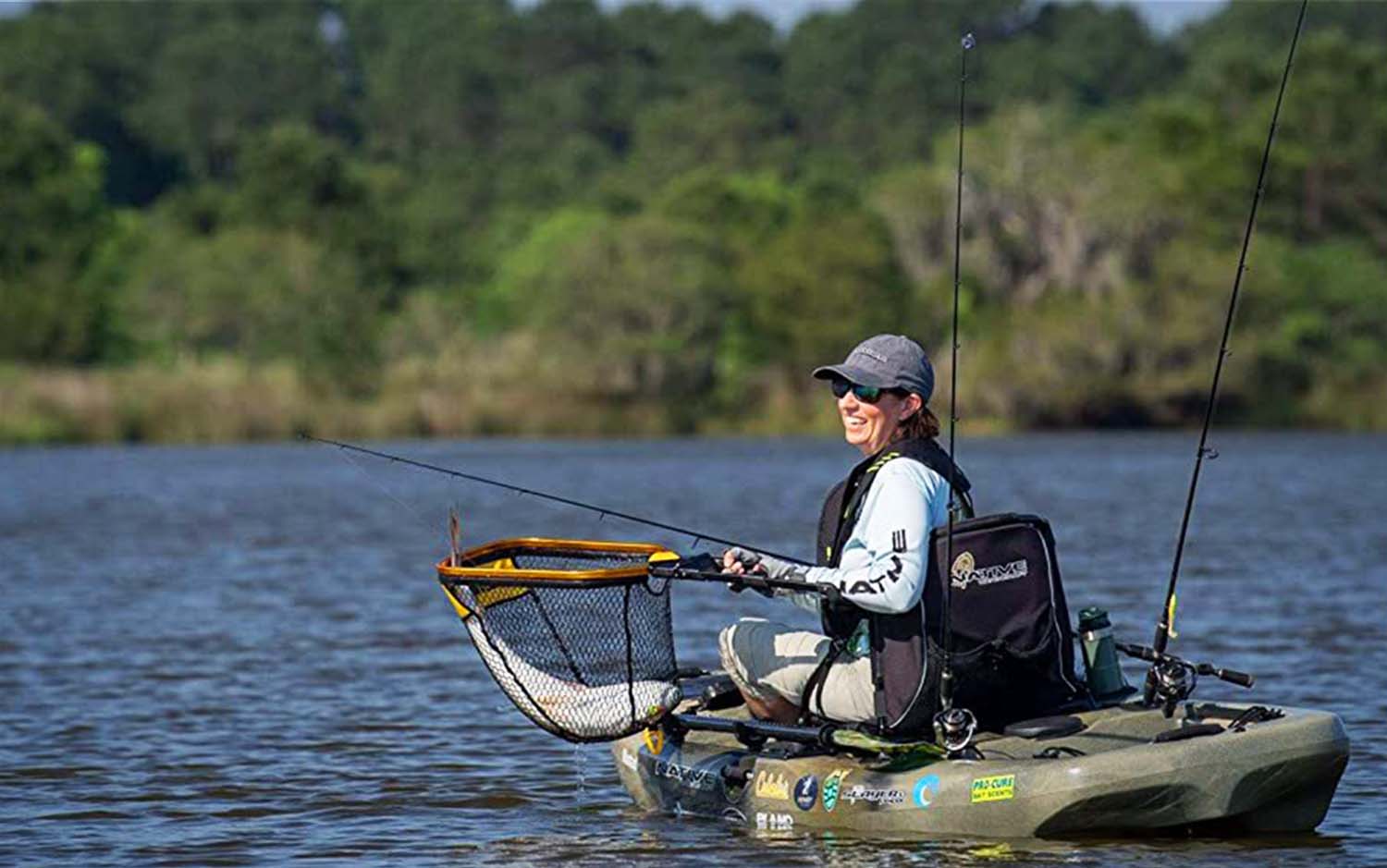 A woman in a kayak holding a best kayak fishing net
