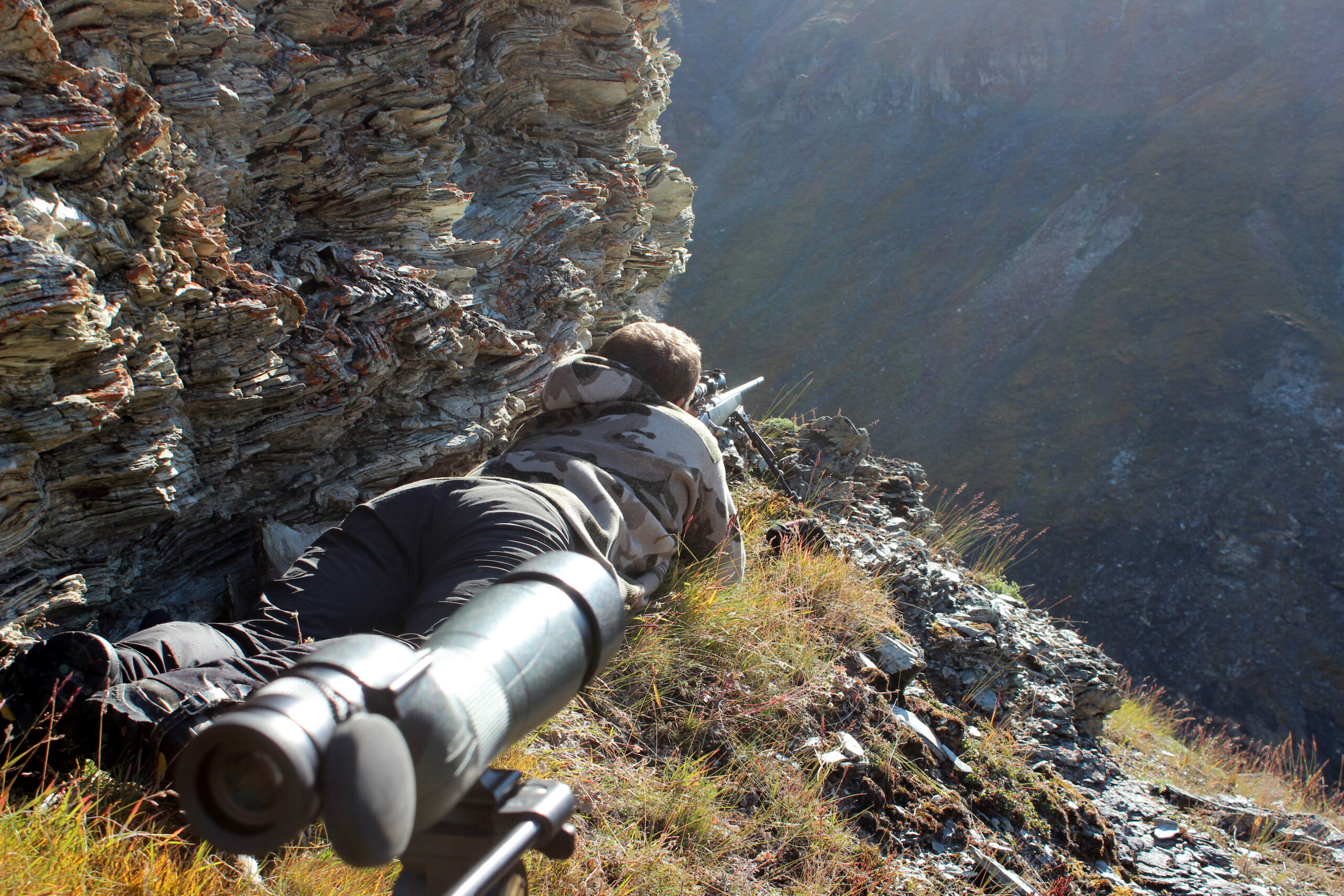 A sheep hunter prepares for a cross-canyon shot