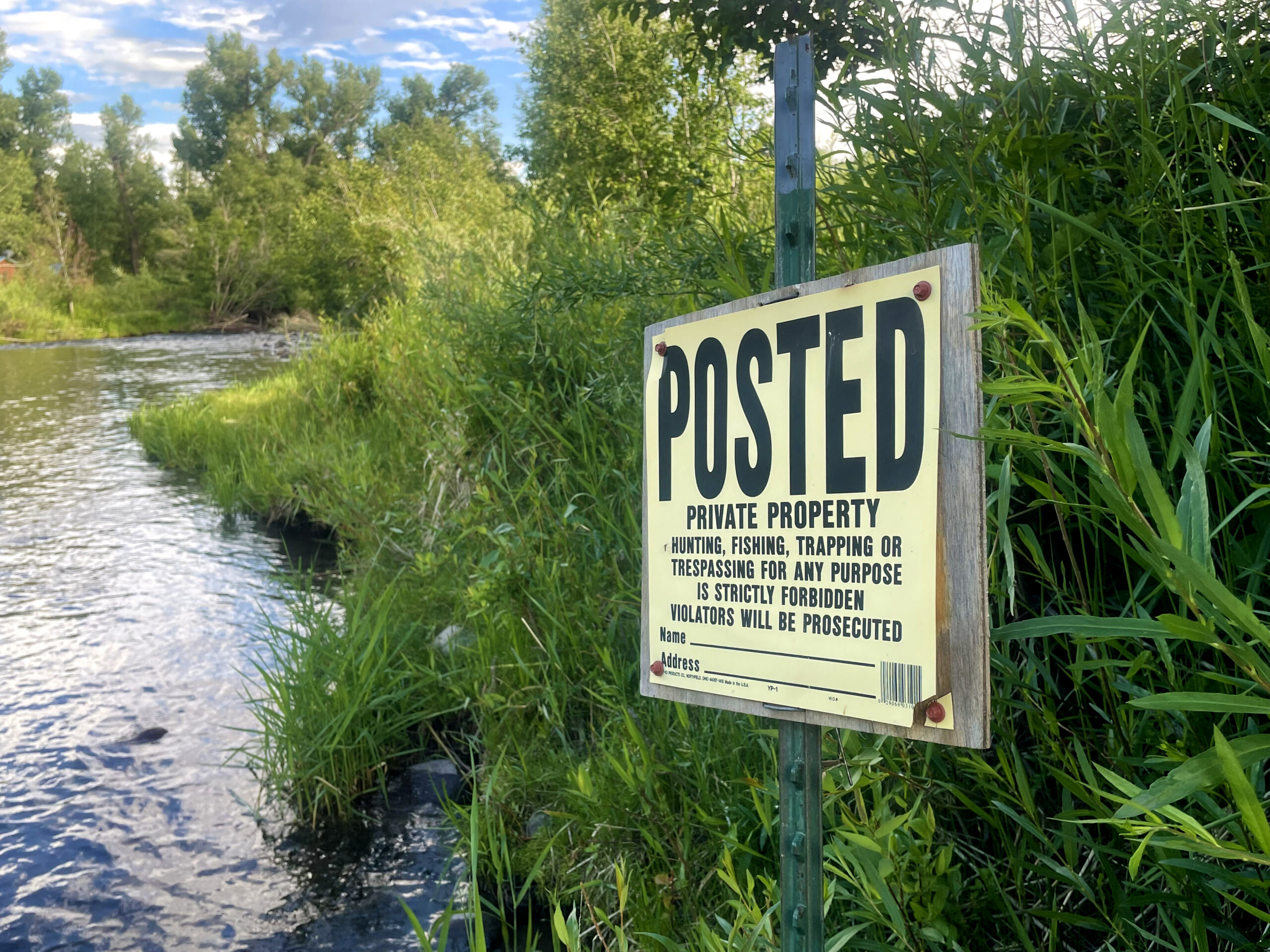 posted sign at stream edge