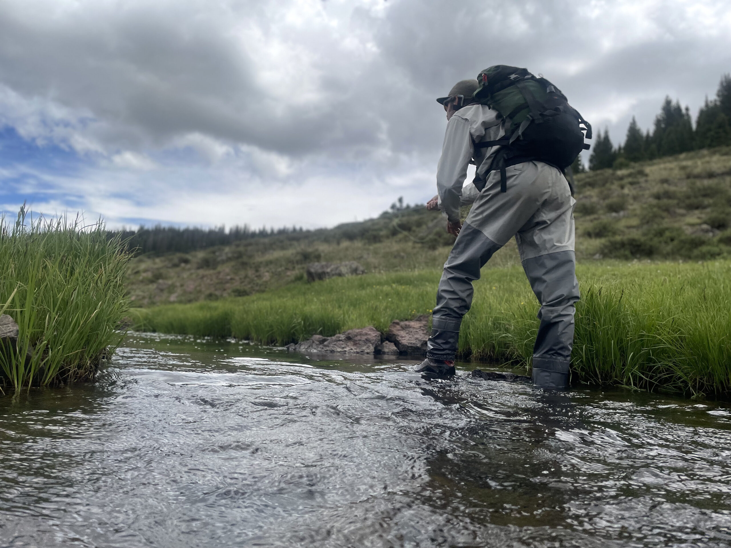 angler wades in stream