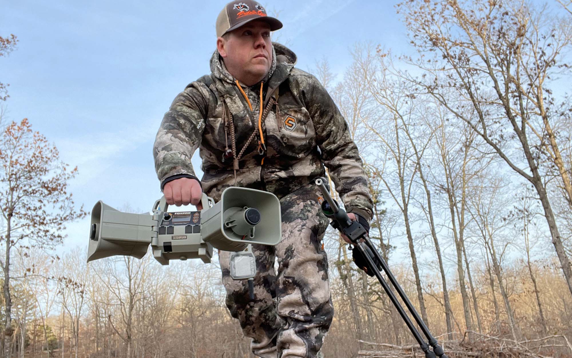 Hunter carrying the FOXPRO XWAVE coyote call through the woods.