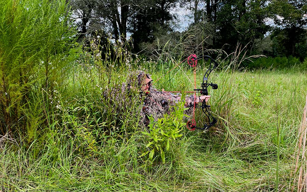 The North Mountain Gear Hybrid Ghillie in a grassy field.