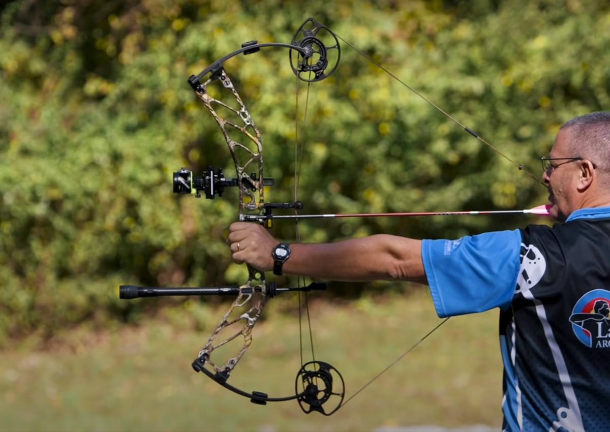 Archer draws bow with one of the best bow stabilizers.