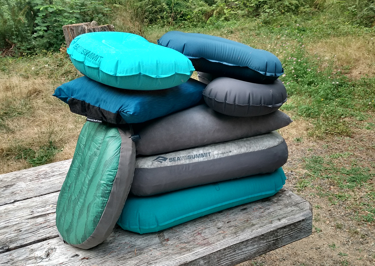 The best backpacking pillows are piled on top of a picnic table.