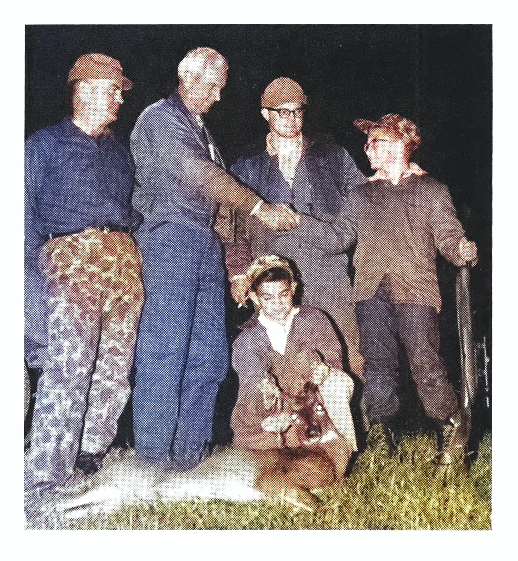 A group of hunters congratulate a kid on his first deer.