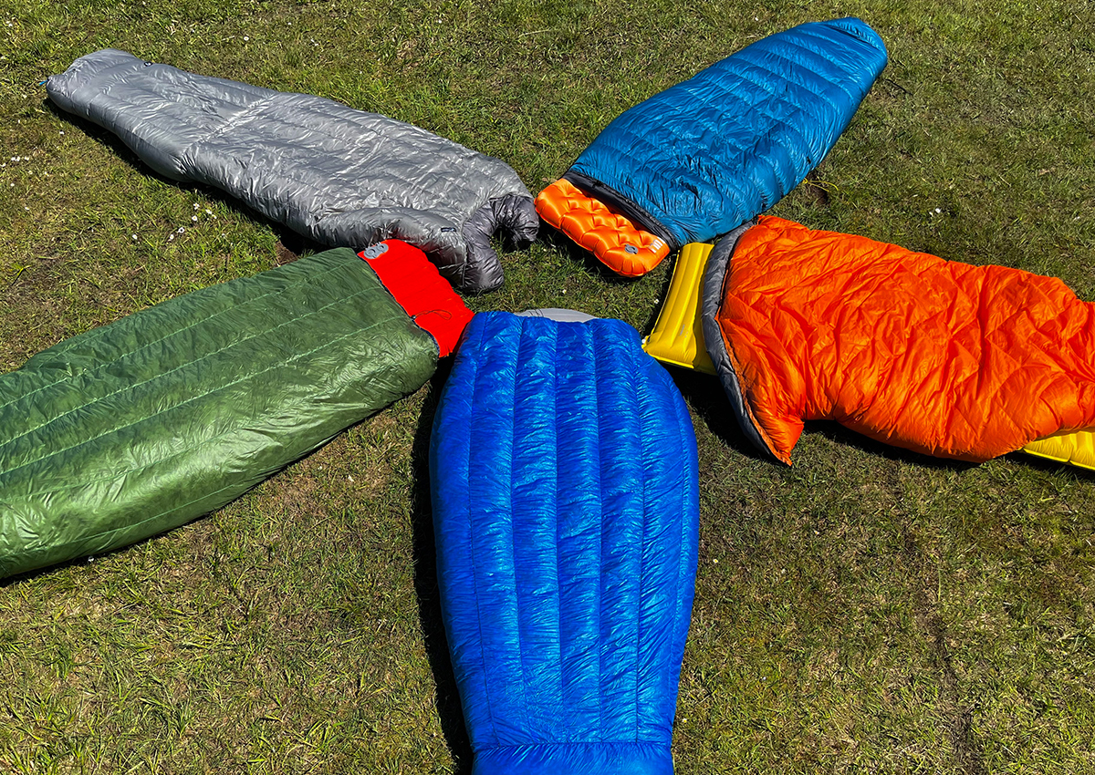 Five of the best backpacking quilts lay in a circle.