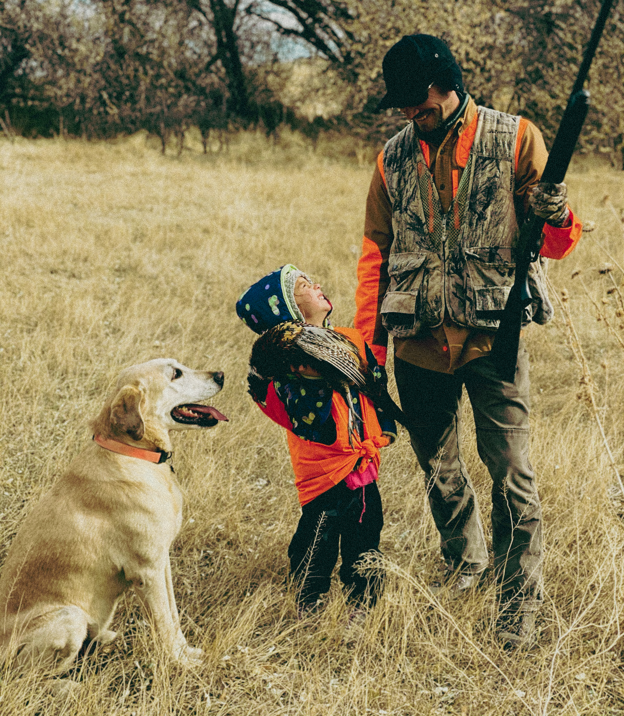 A father and daughter and dog pheasant hunting.