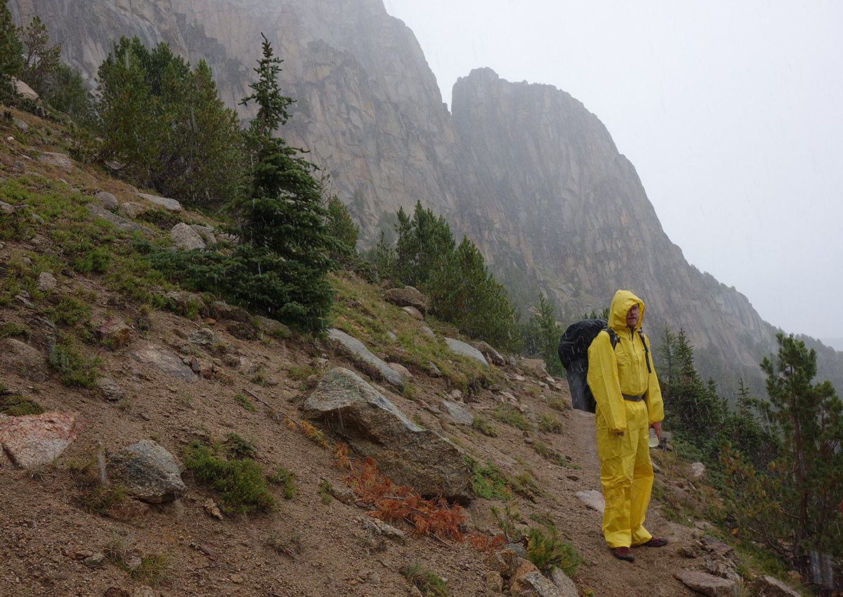 A hiker wears rain gear in wet conditions.