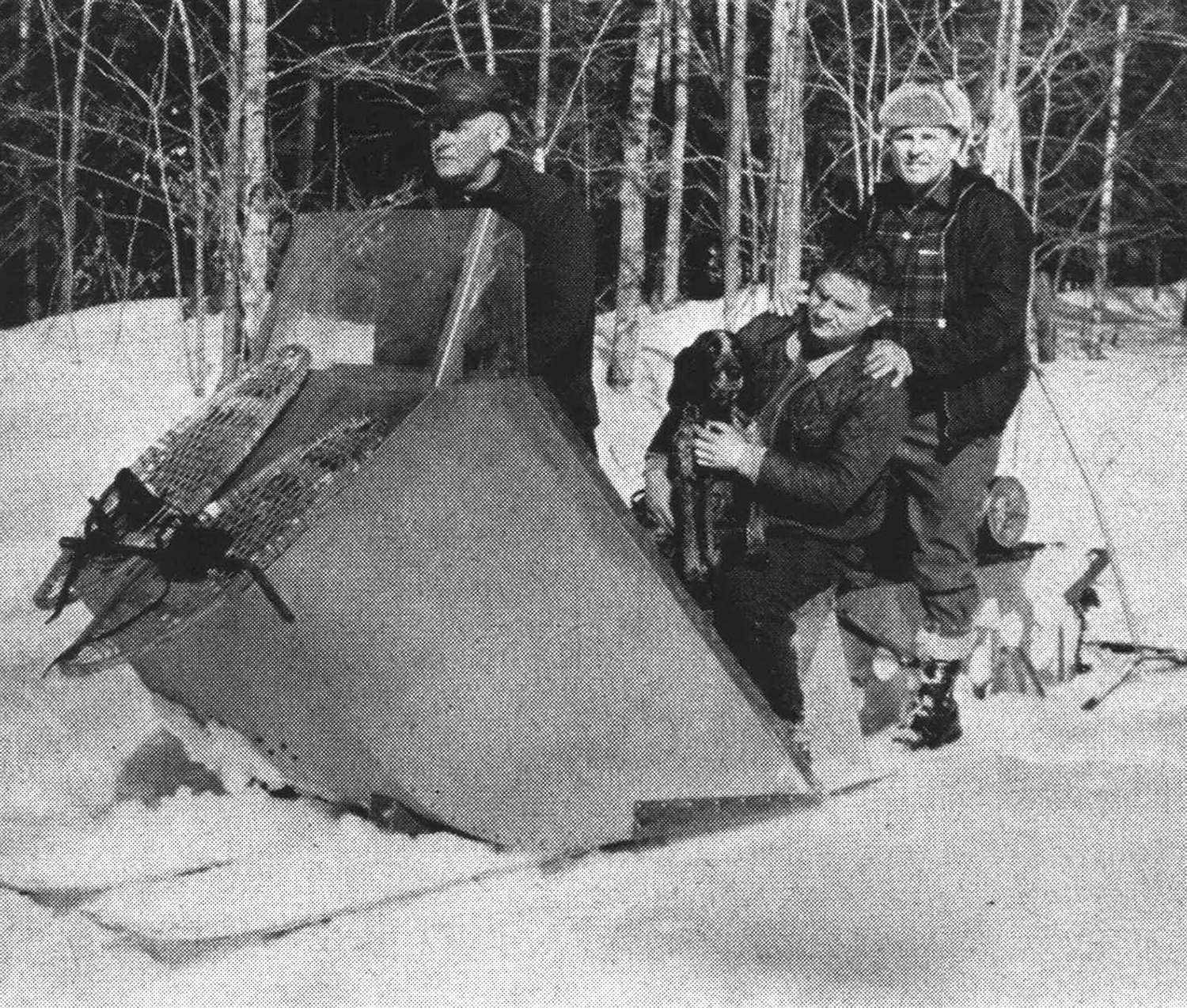 three hunters and one dog on a snow sled