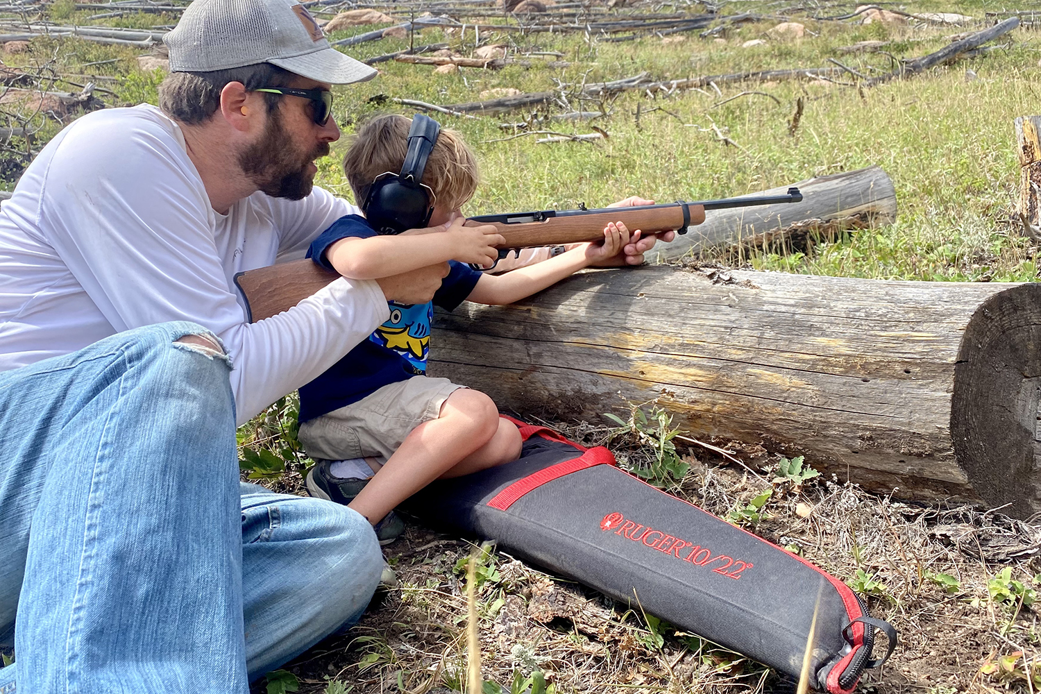 man teaches child to shoot