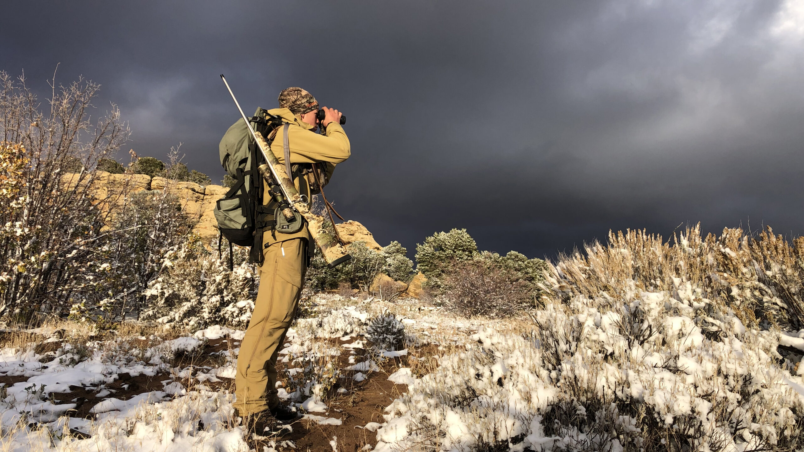 hunter peers through binoculars