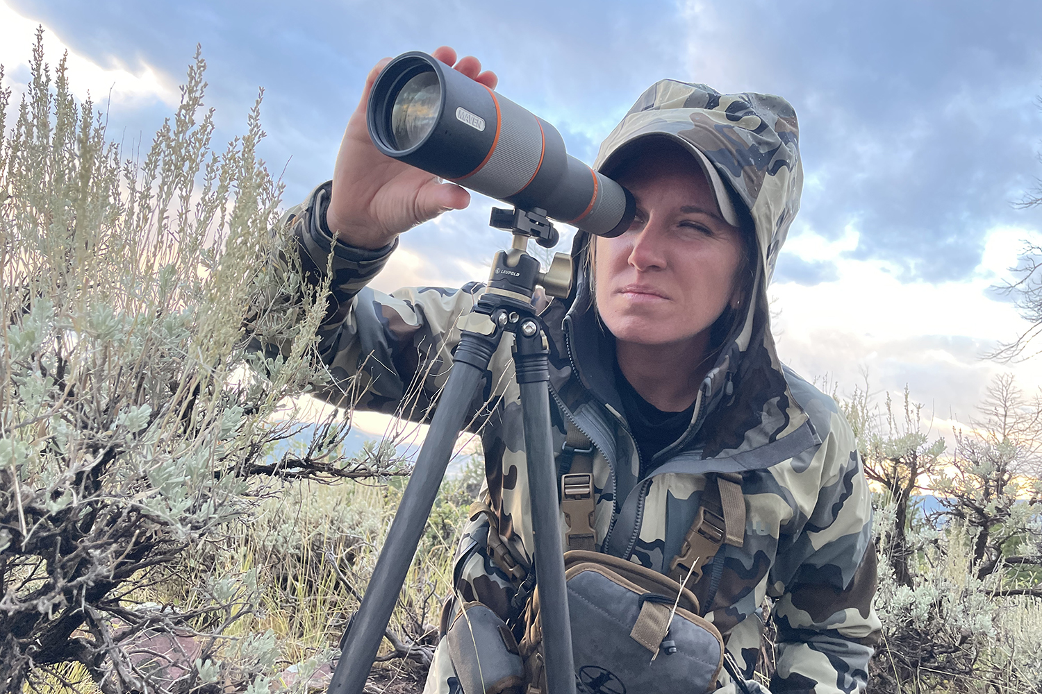 hunter peers through spotting scope