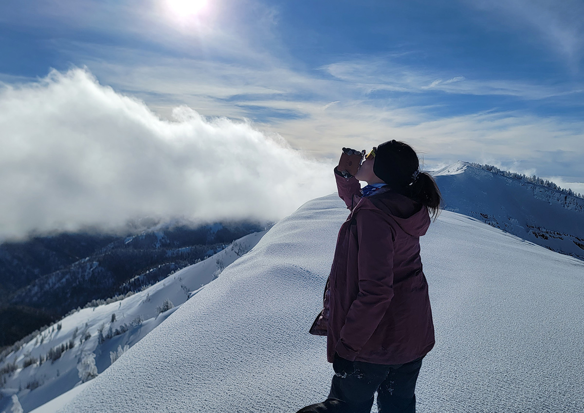 Author drinks one of the best whiskeys for the backcountry on a peak.