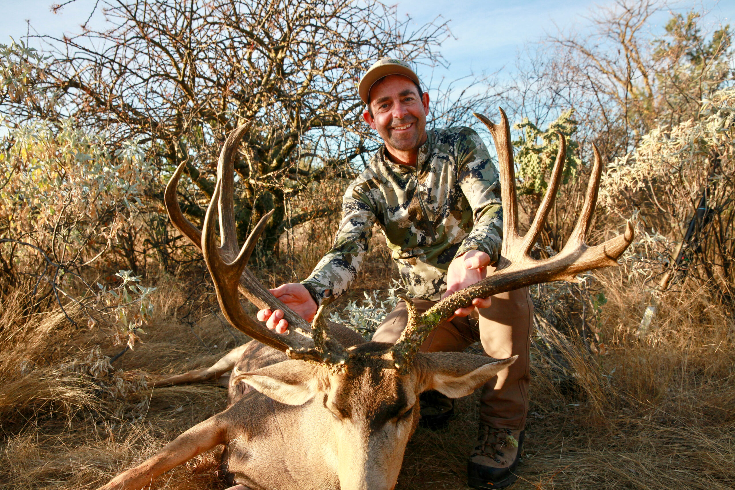 A hunter with a 220-inch mule deer.