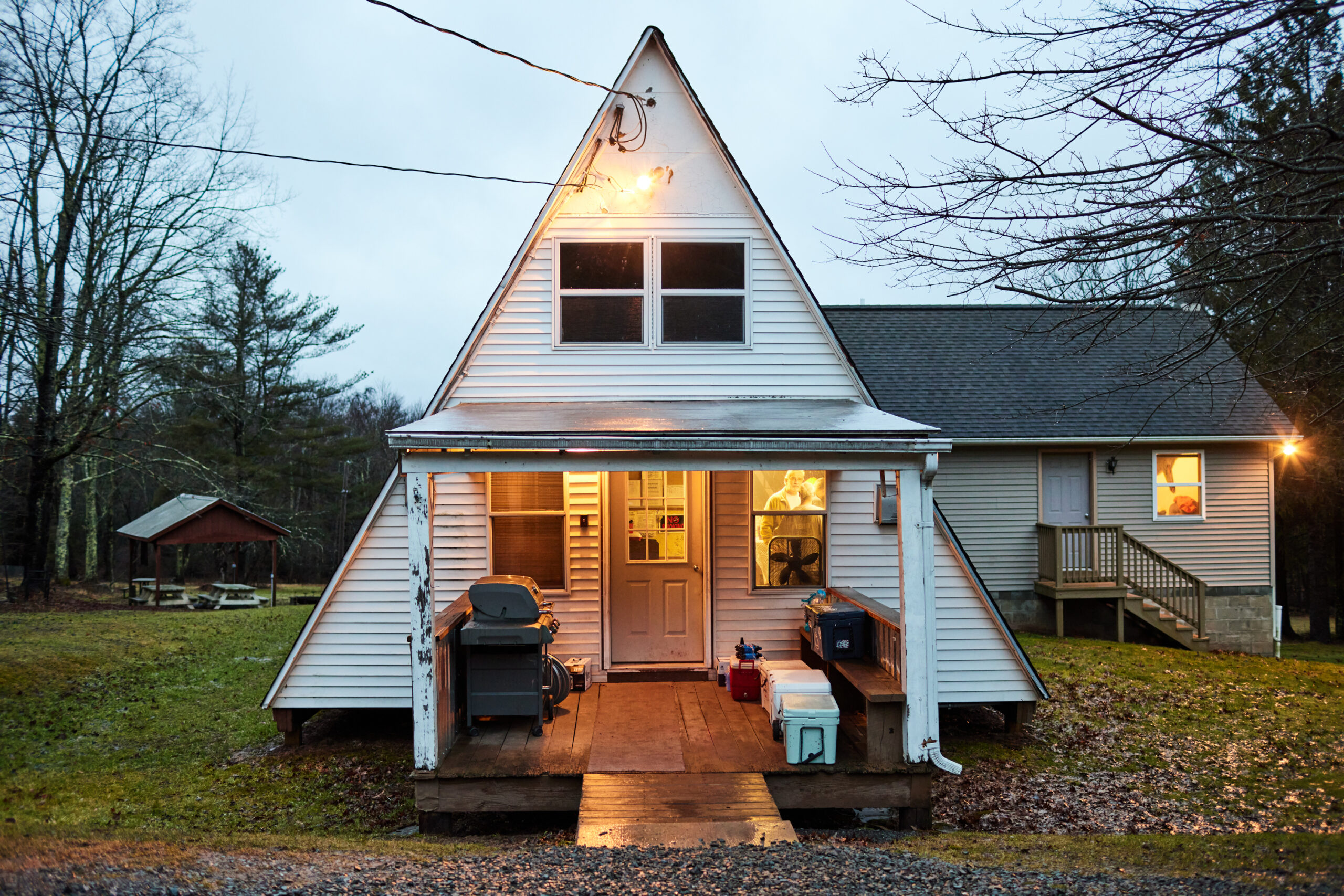 A white A-frame cabin in Pennsylvania that serves as a hunting camp.