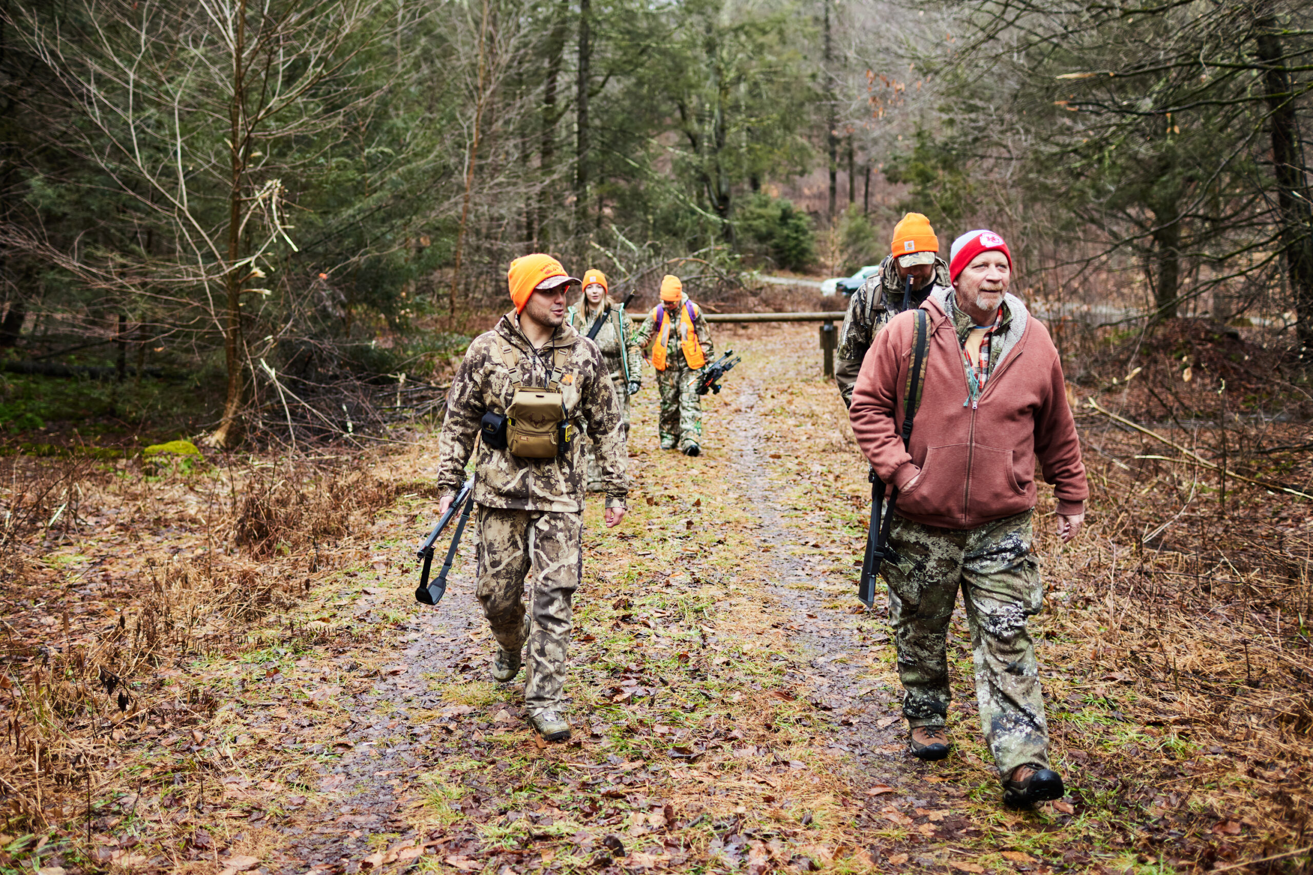 Flintlock deer hunters walk down a logging road during a deer drive.