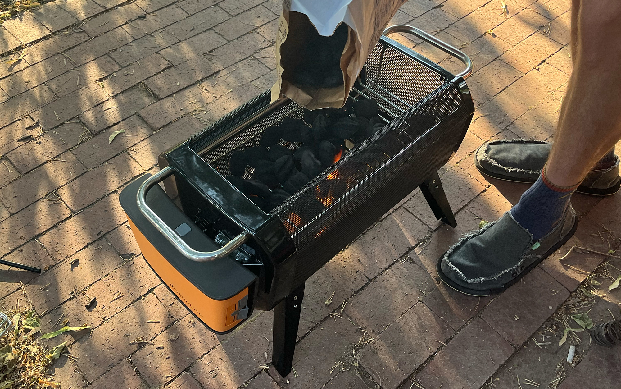 Man pours charcoal on Biolite FirePit+.