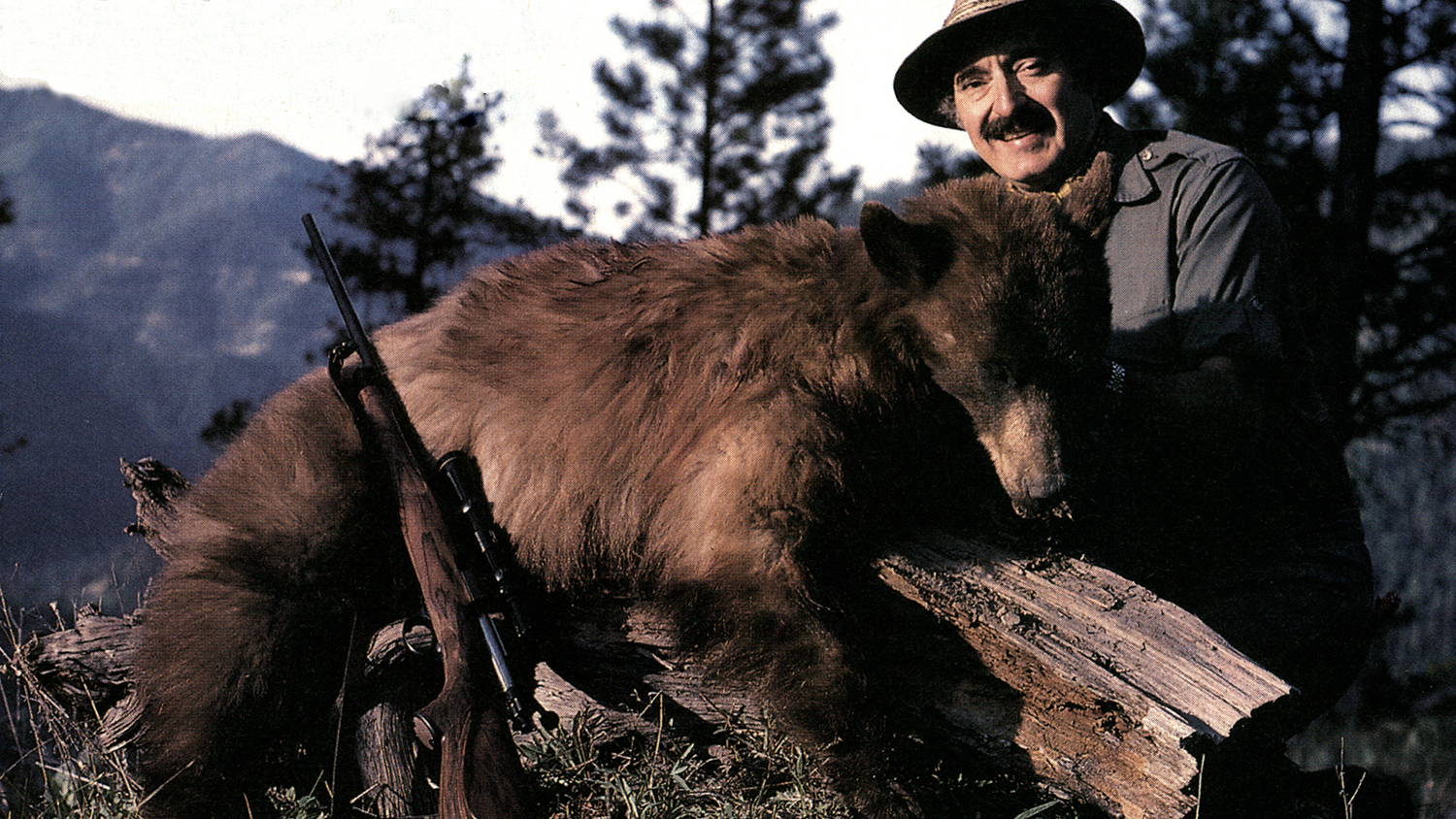Jim Carmichel with rifle and bear.
