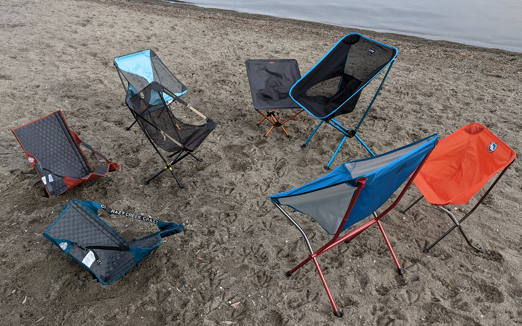 The best backpacking chairs sit on a sandy beach.