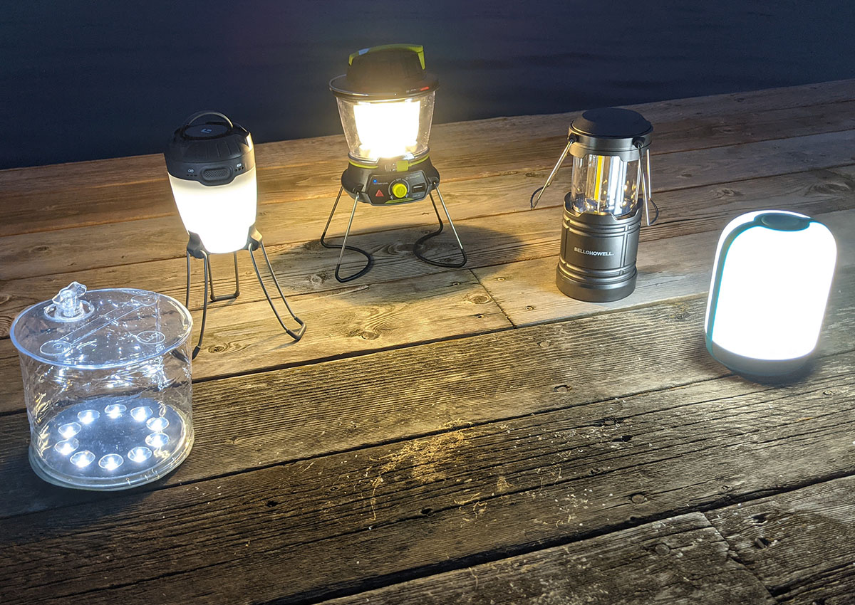 The best camping lanterns sit lit up on a dock.
