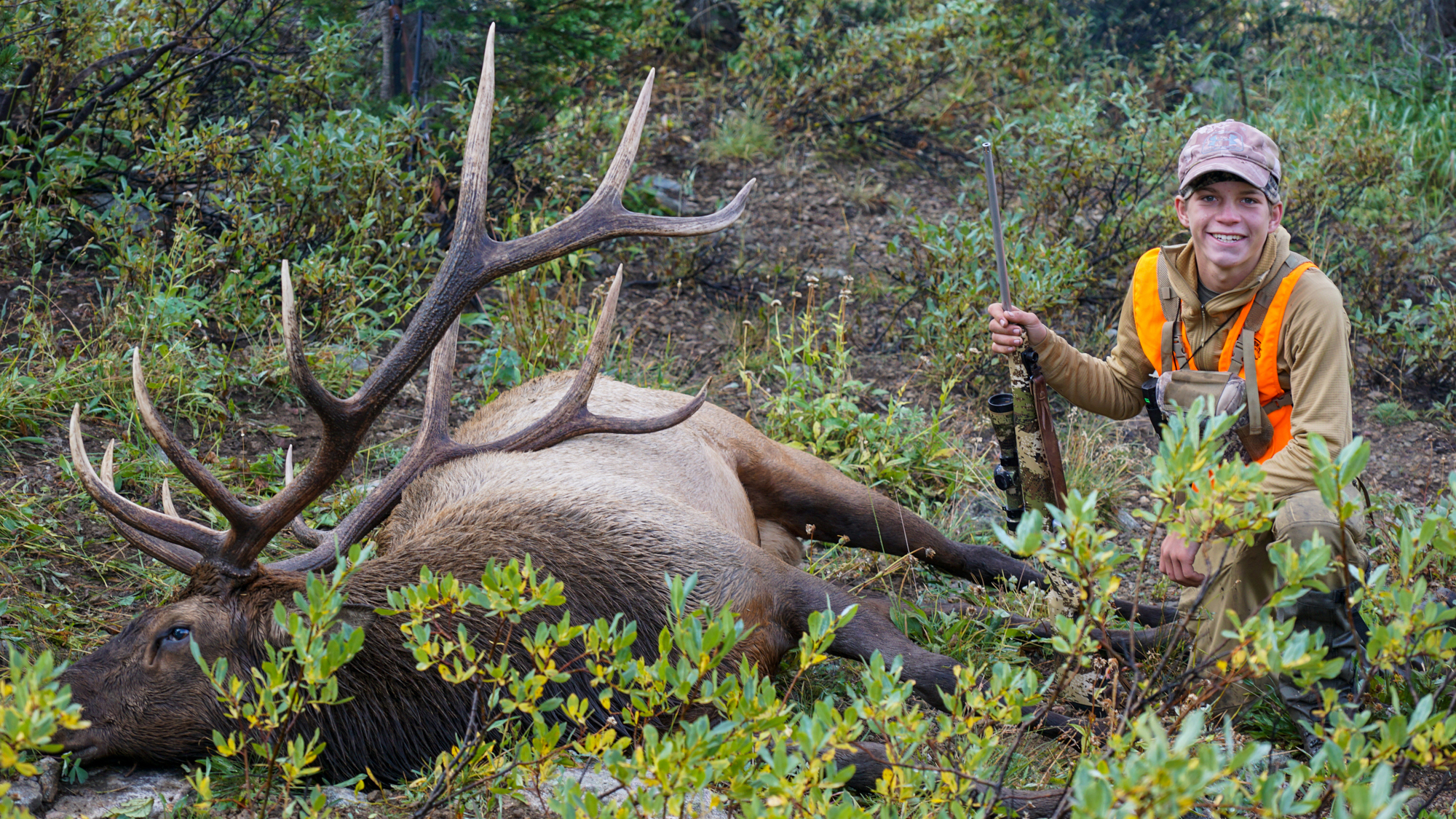 Young rifle hunter poses with elk