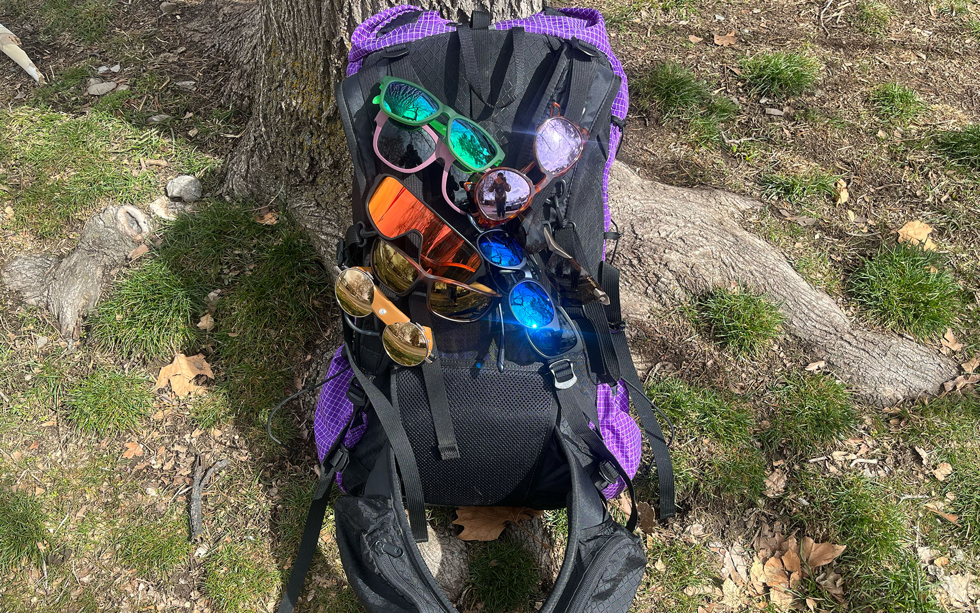 The best hiking sunglasses are attached to a loaded backpack.