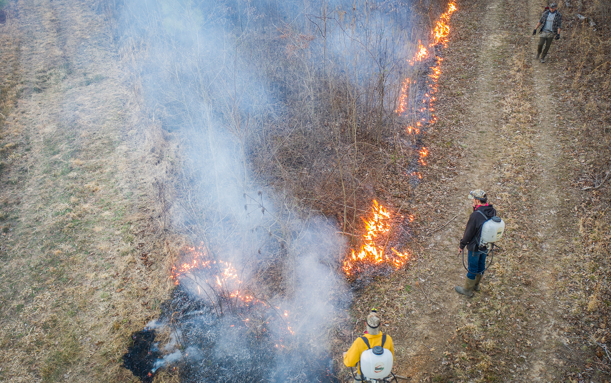 Using backpack sprayers to spray water during a controlled burn.