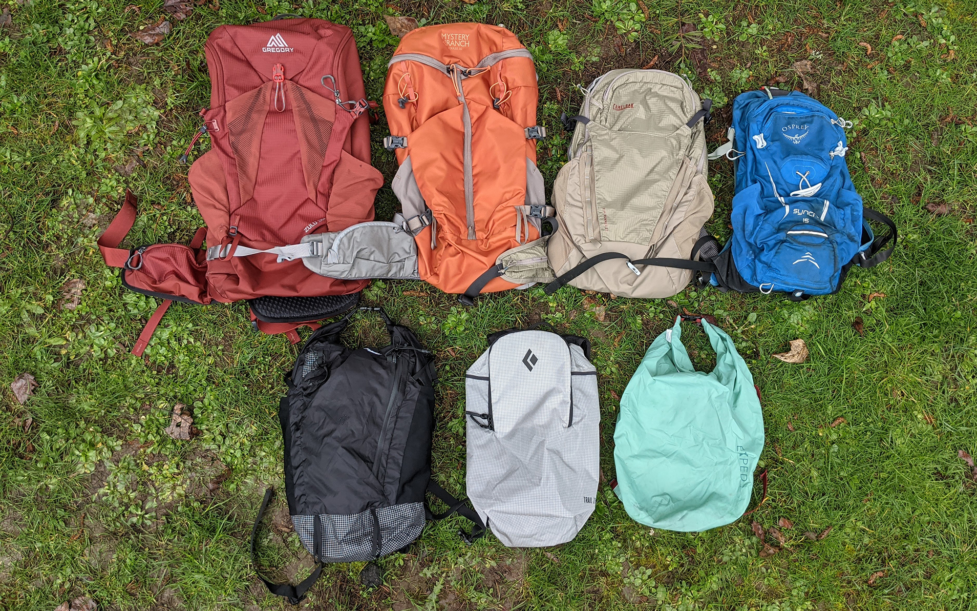 The best hiking daypacks sit in the grass.