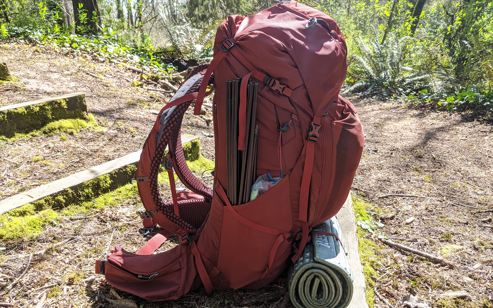 The top compression strap of the Gregory Baltoro is positioned too high to provide additional security for tent poles, and must be unclipped to access the front zipper entry to the main compartment.