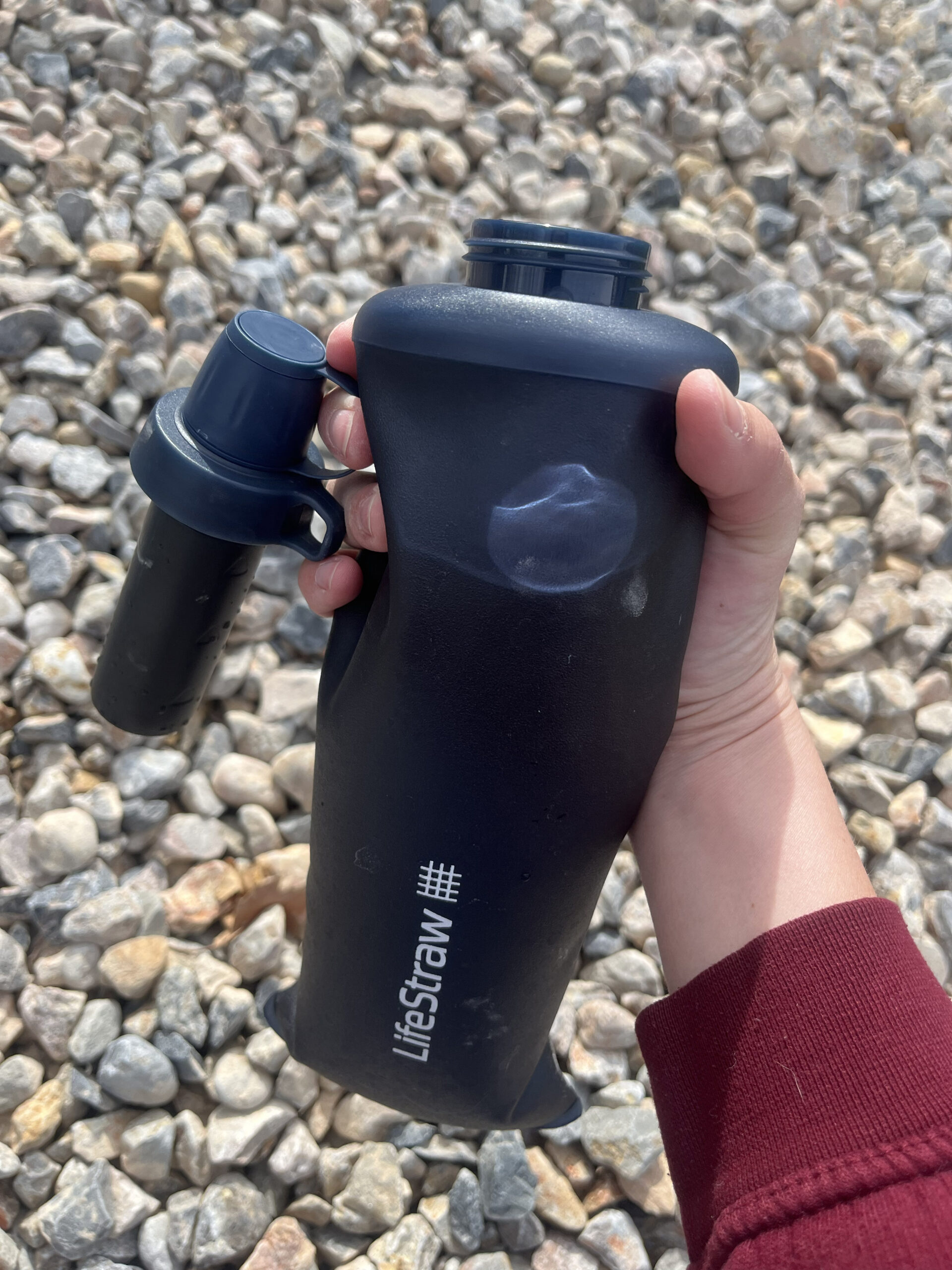 The LifeStraw Peak collapsible water bottle cap has a loop to keep the filter off the ground while filling.