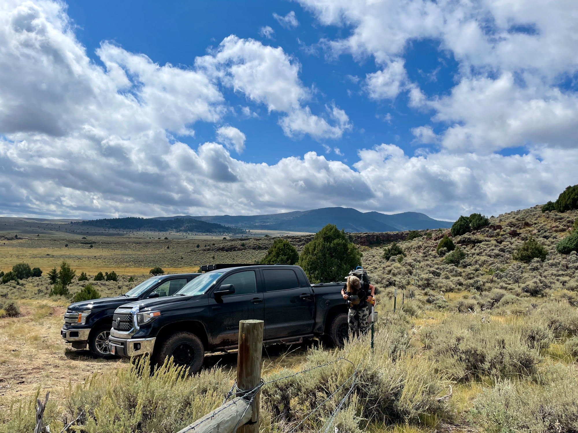 Two trucks parked at a trailhead in elk country.