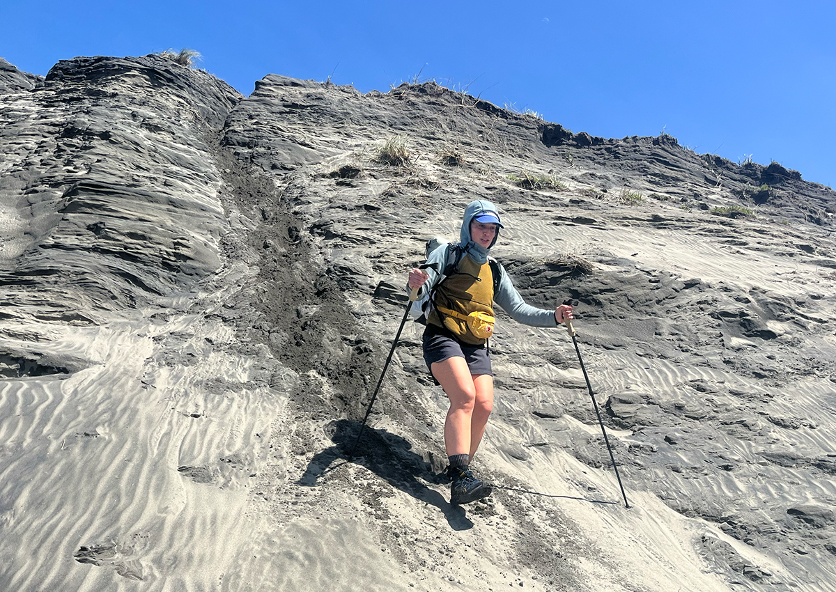 Hiker descends sandy hill with a pair of the best trekking poles.