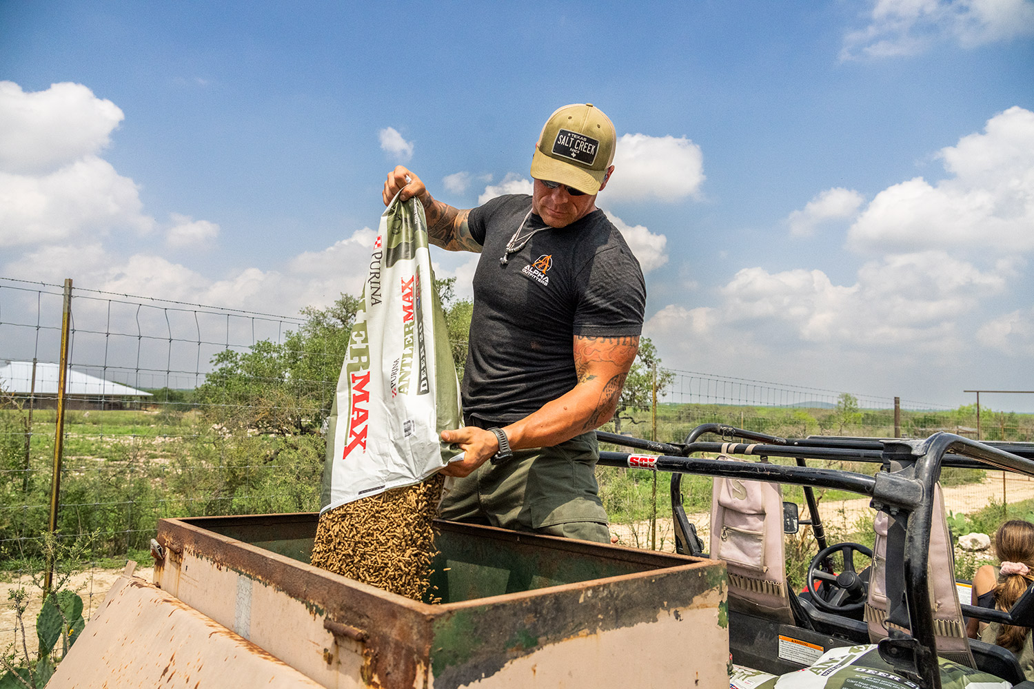 Josh Risner fills a feeder. The ranch goes through roughly 26,000 pounds of protein feed every two to three weeks.