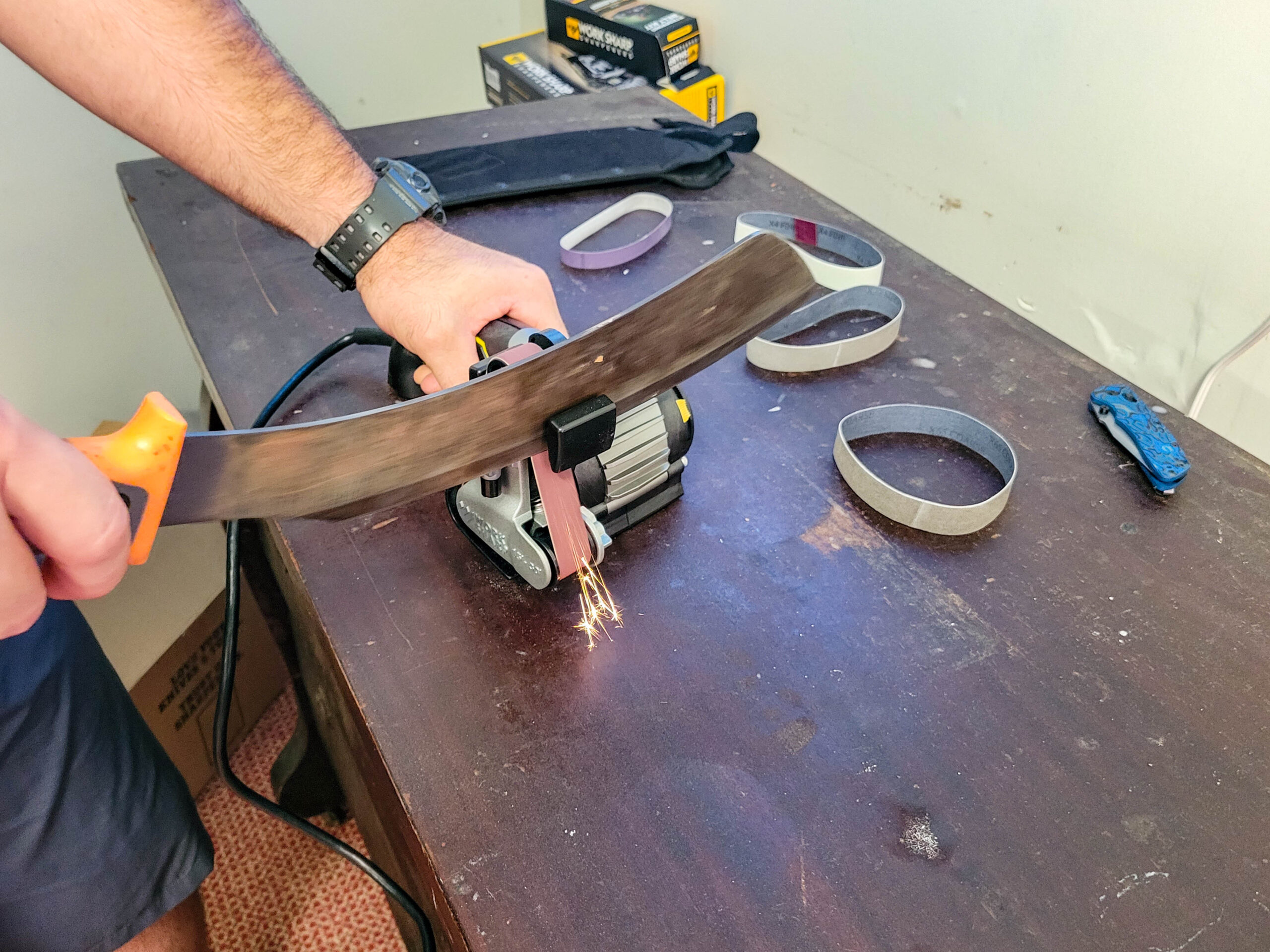 The Work Sharp electric knife sharpener sharpening a machete.