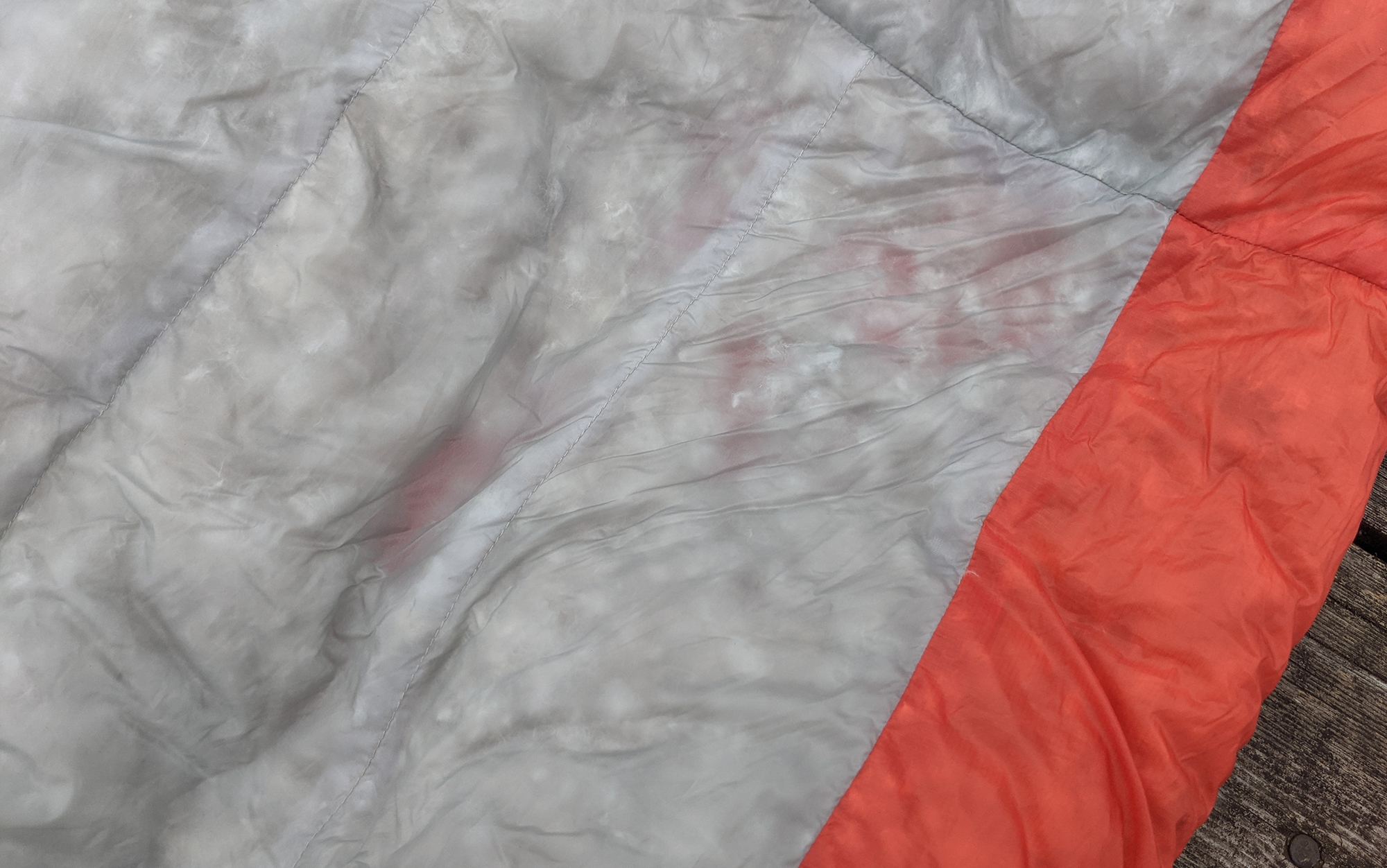 The orange peaking through the grey down-filled baffles shows the potential for cold spots that exists in many down sleeping bags. 
