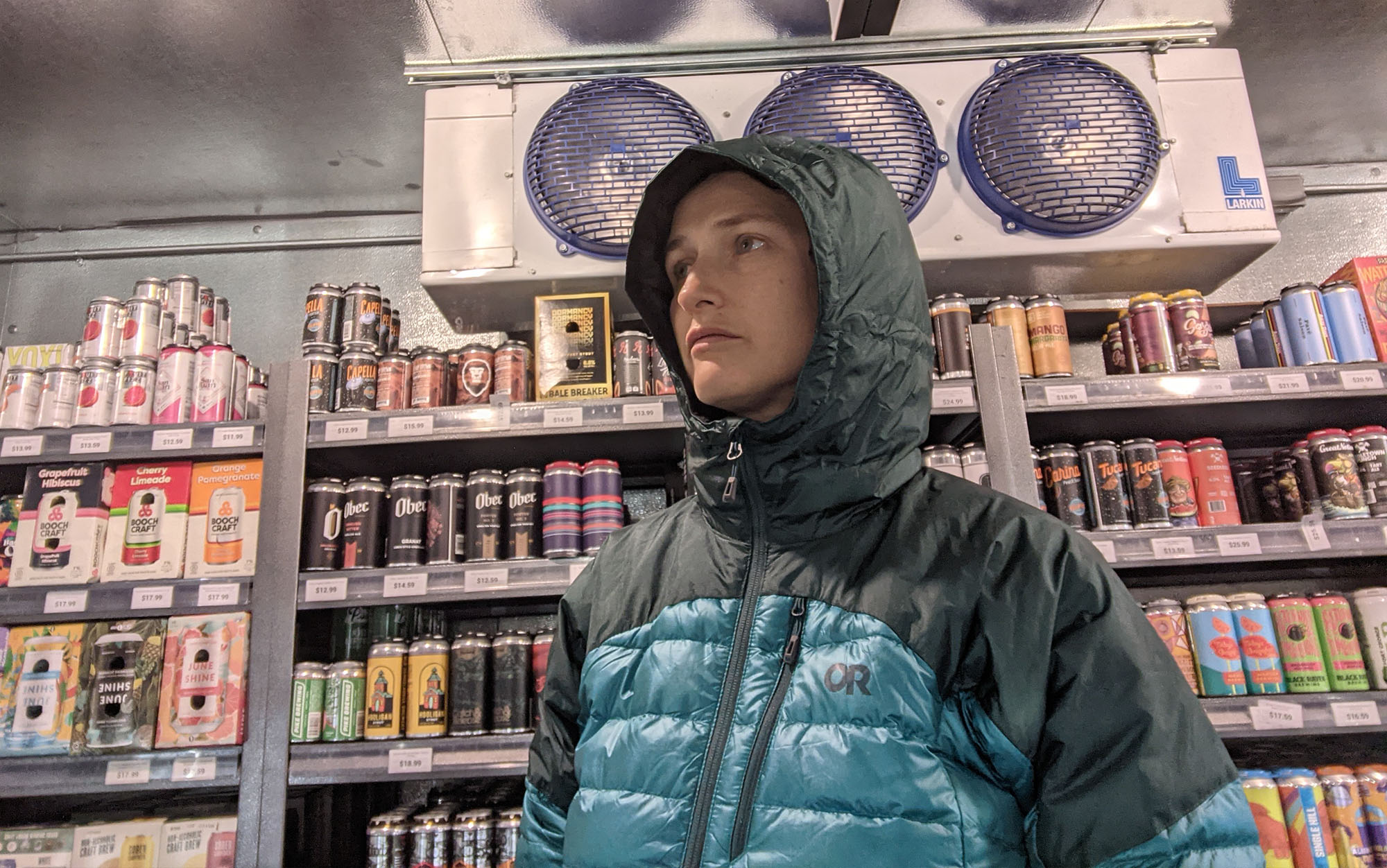 Testing the lofting potential of the Outdoor Research Helium Down Jacket in front of the refrigeration hardware of a local barâs walk-in beer closet. 