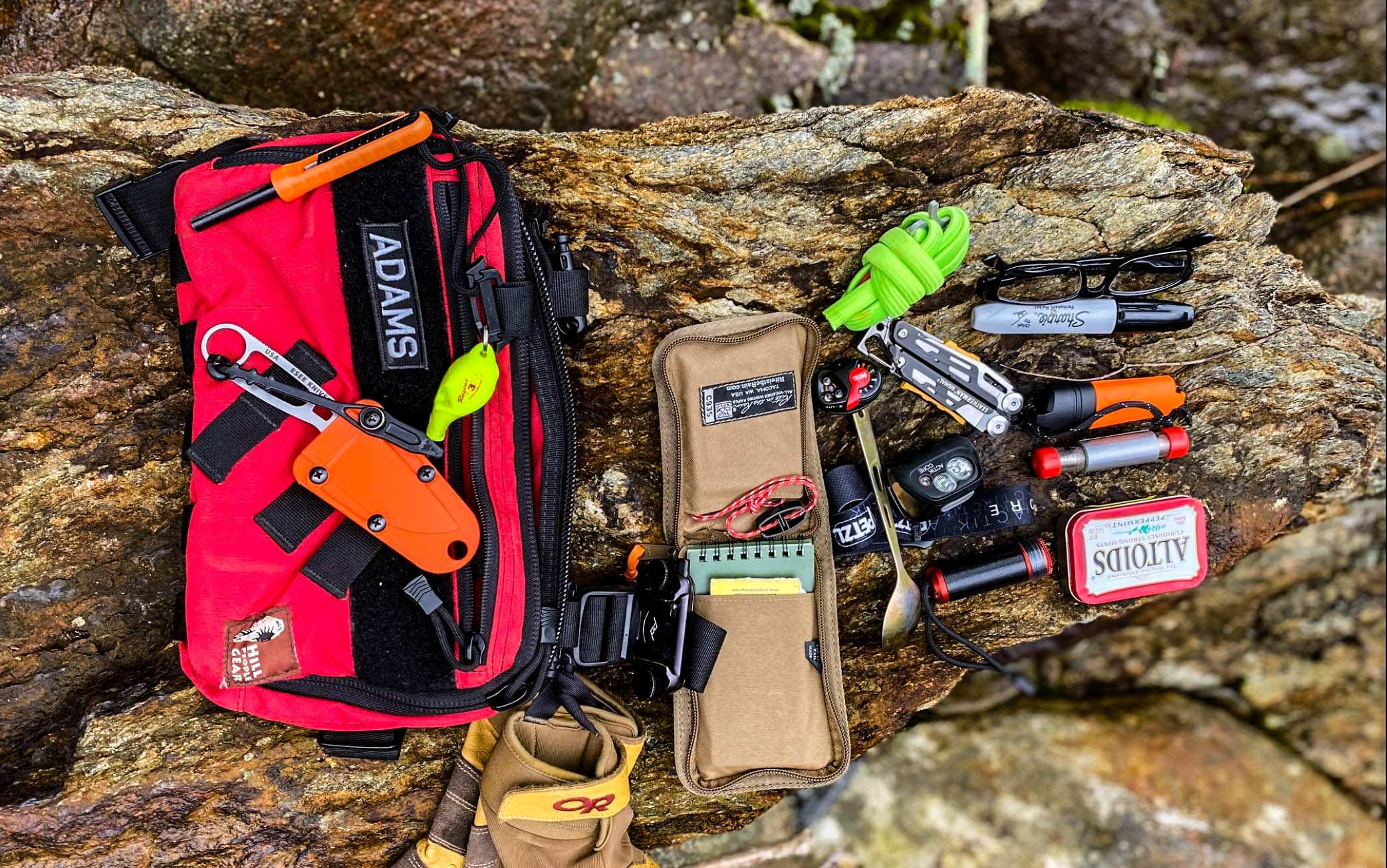 Survival kit laid out on a log.