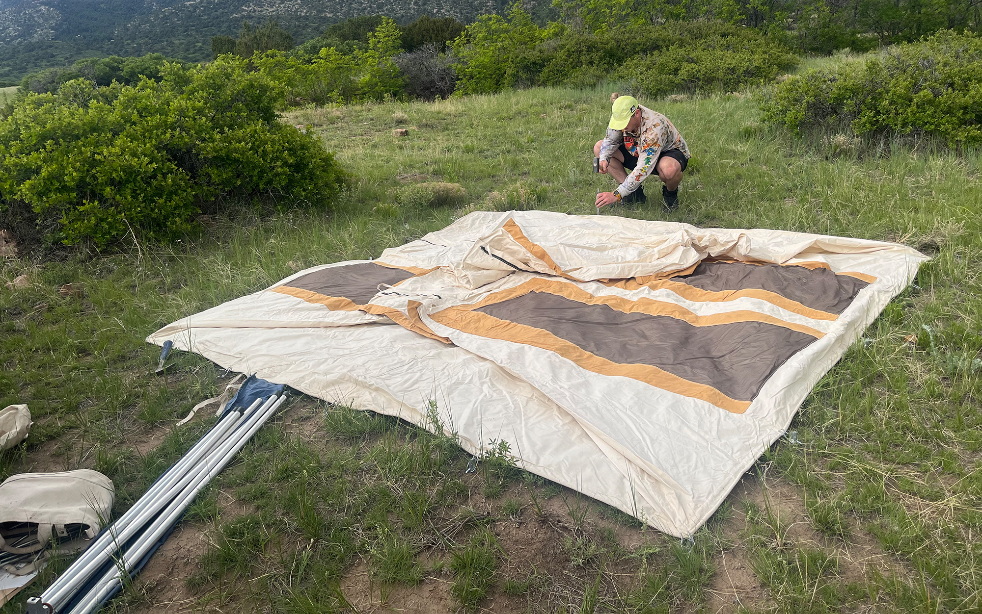 Man stakes down tent.