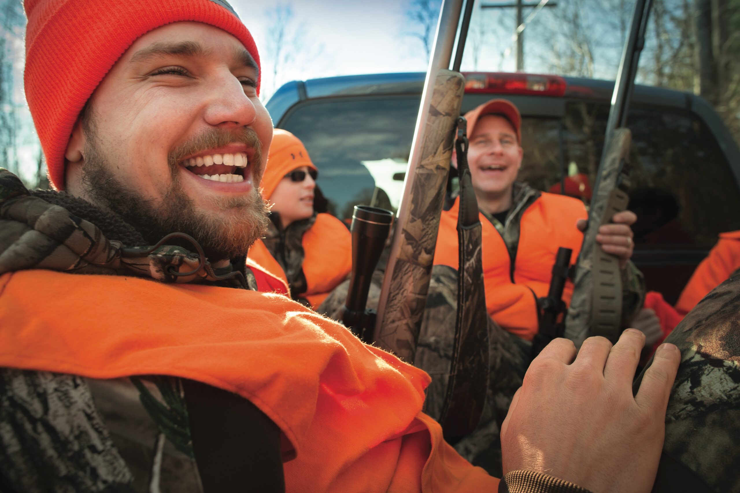 Happy deer hunters gathered in a truck.
