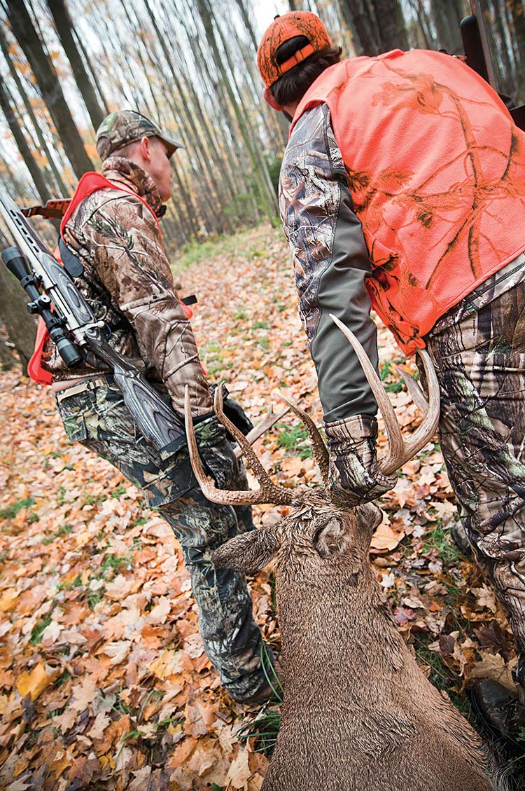 hunters dragging buck back to camp