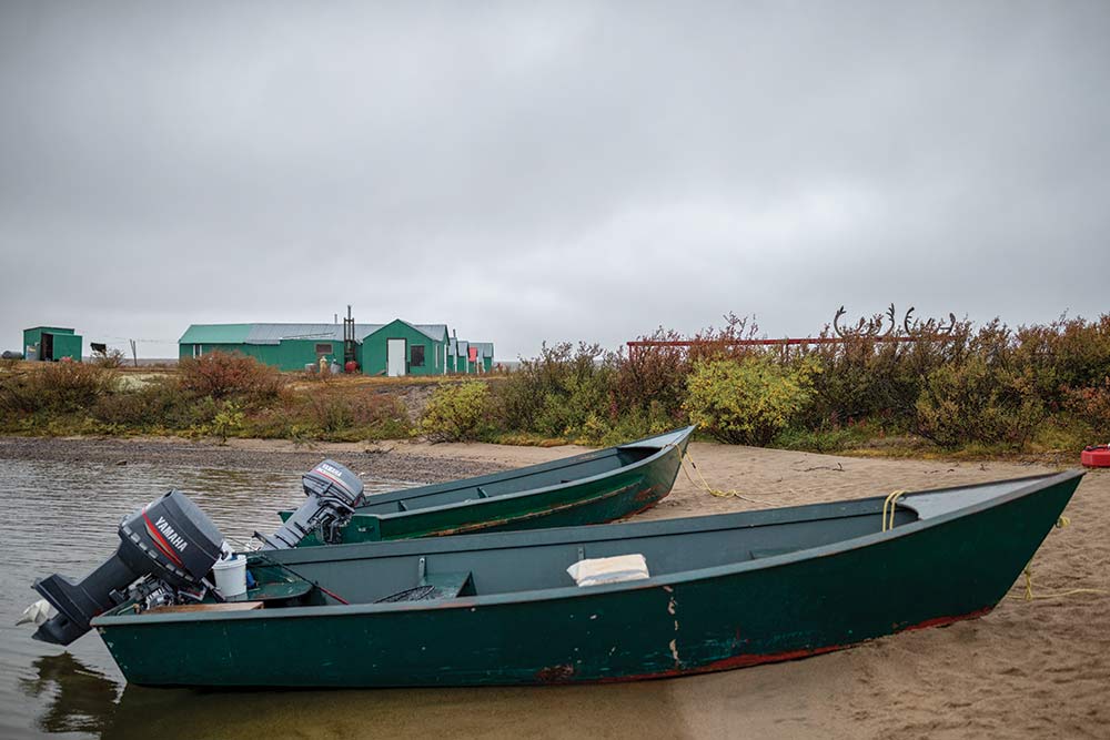 two boats sitting on a shore at hunting camp in quebec