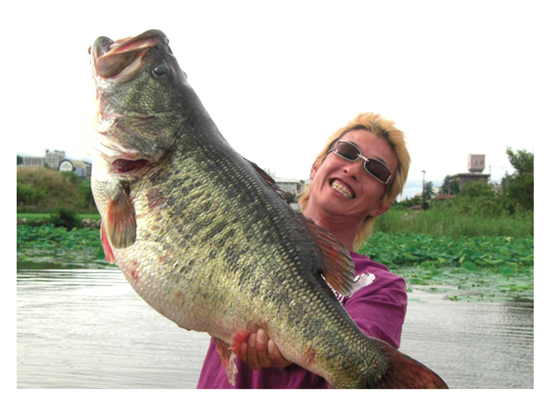 A Japanese angler holds up the world-record largemouth bass.