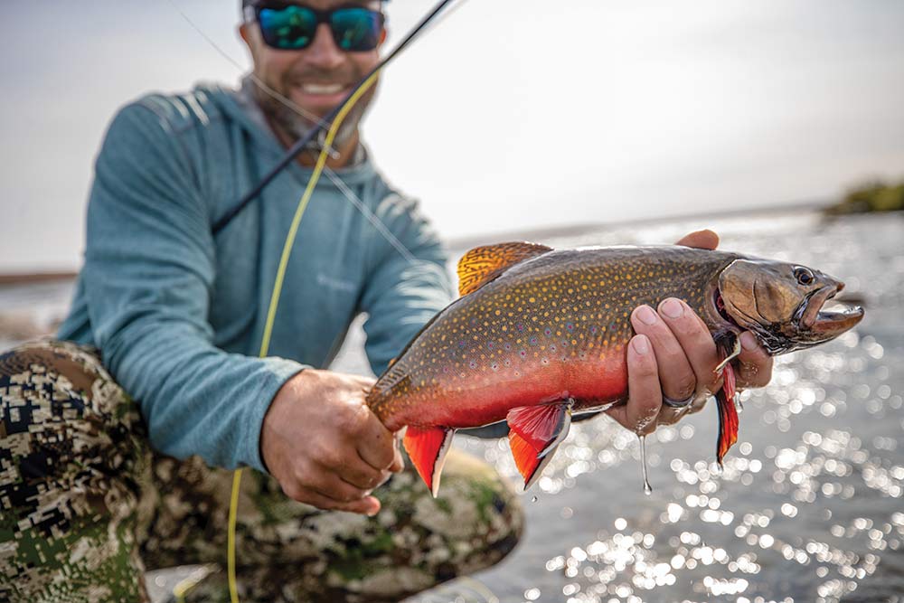 fisherman holding up a brook trout