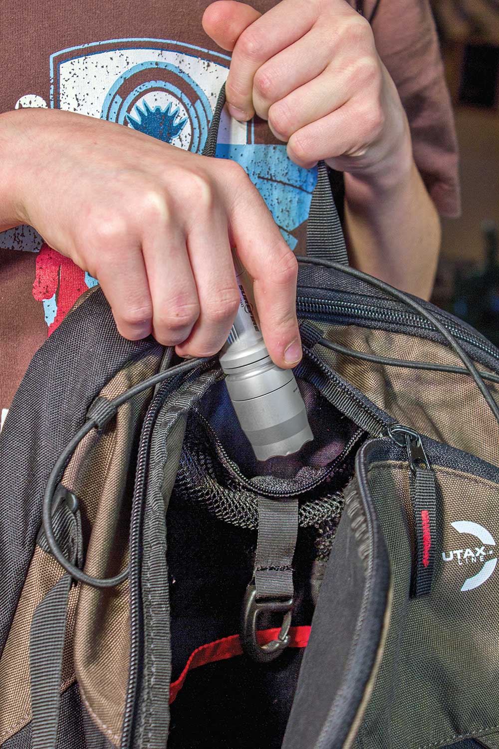 A small LED flashlight in a backpack